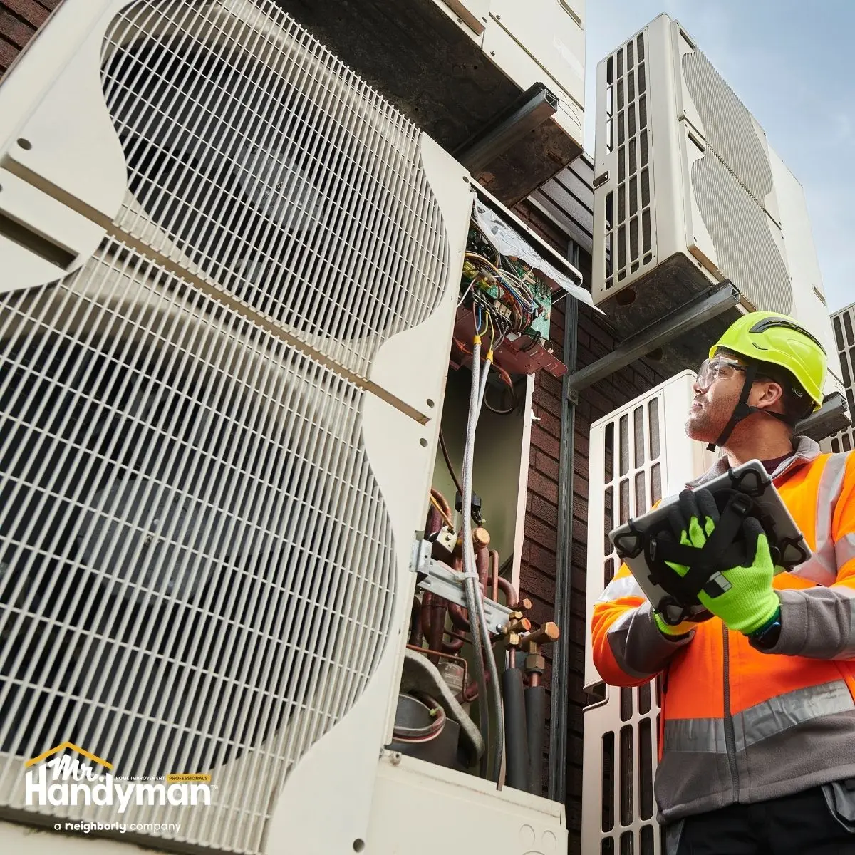Technician inspecting outdoor HVAC units.