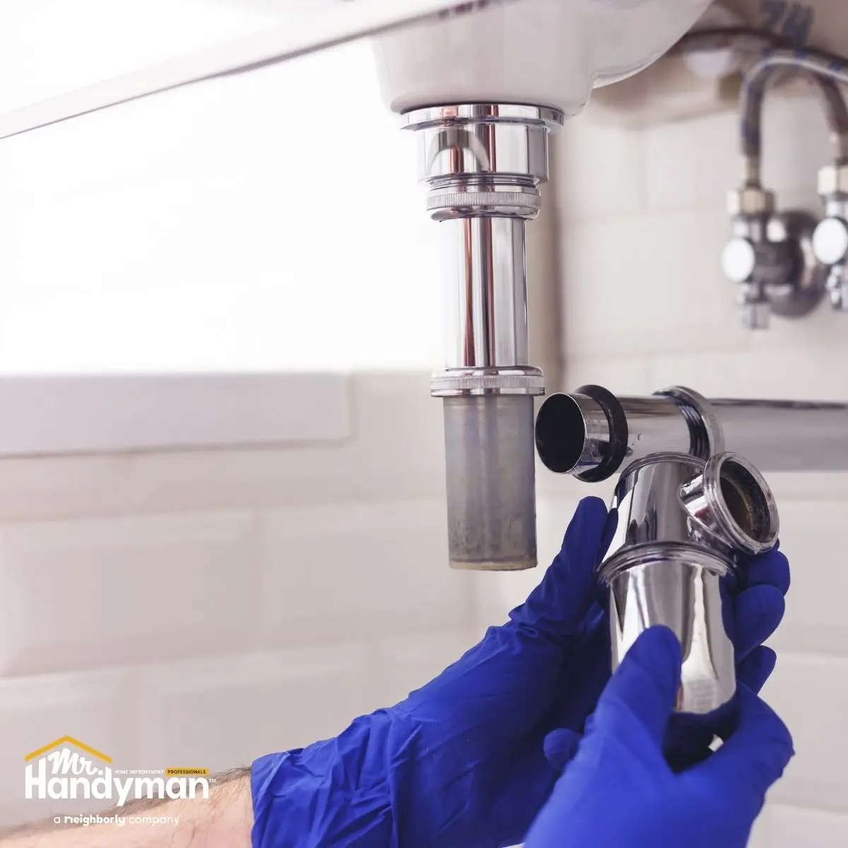 Handyman repairing locker room plumbing in Oklahoma City gym.