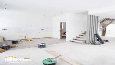 room under construction with unfinished walls and floors exposed wiring and a metal staircase.