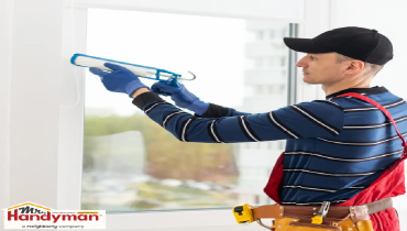 A person holds a caulking gun.