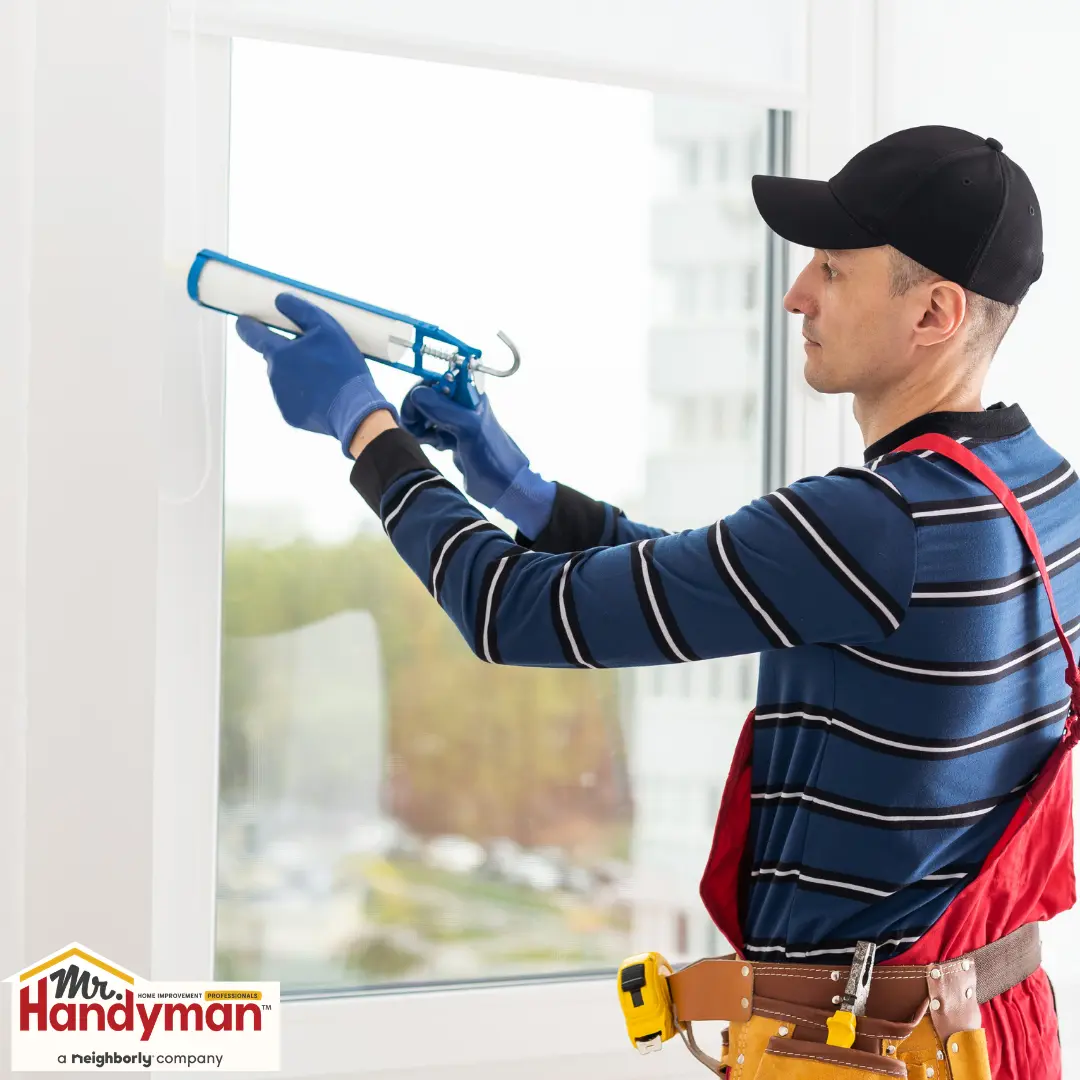 A person holds a caulking gun.