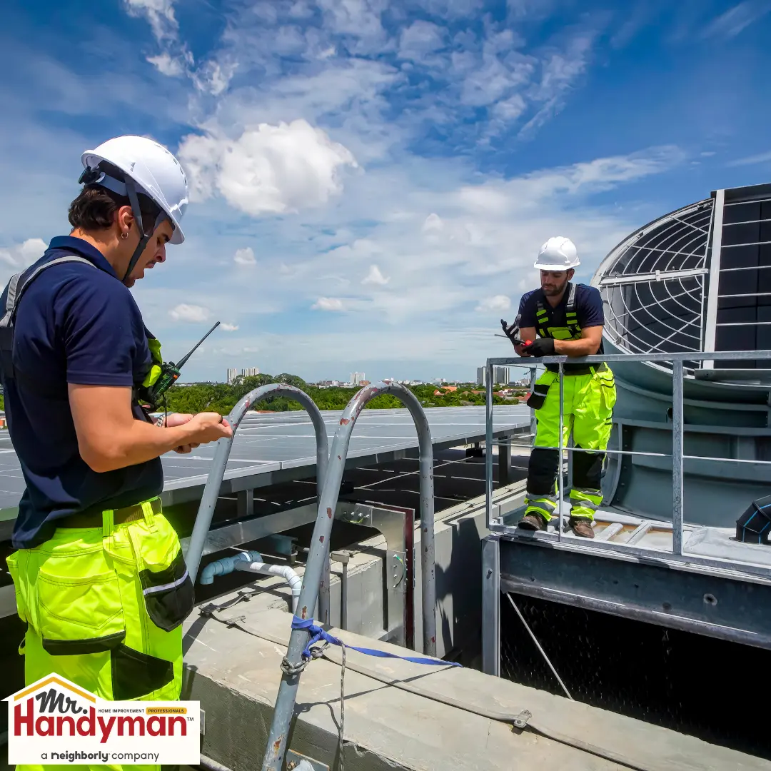 Two workers on a rooftop.