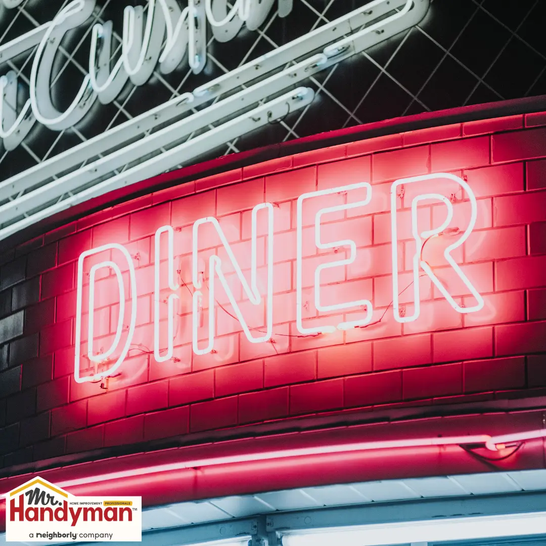 Neon diner sign glowing on a tiled wall.