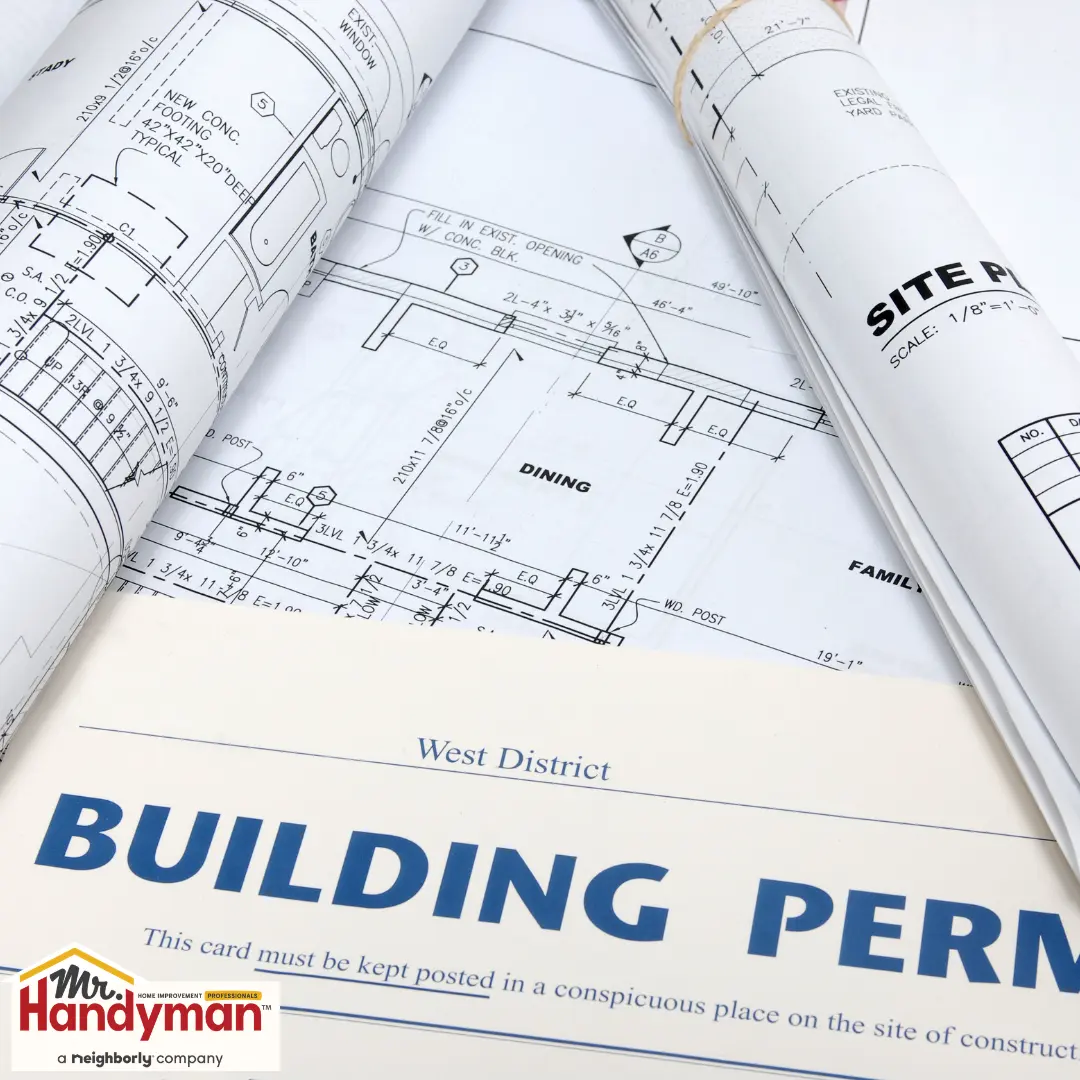 Rolled architectural blueprints and a building permit document.