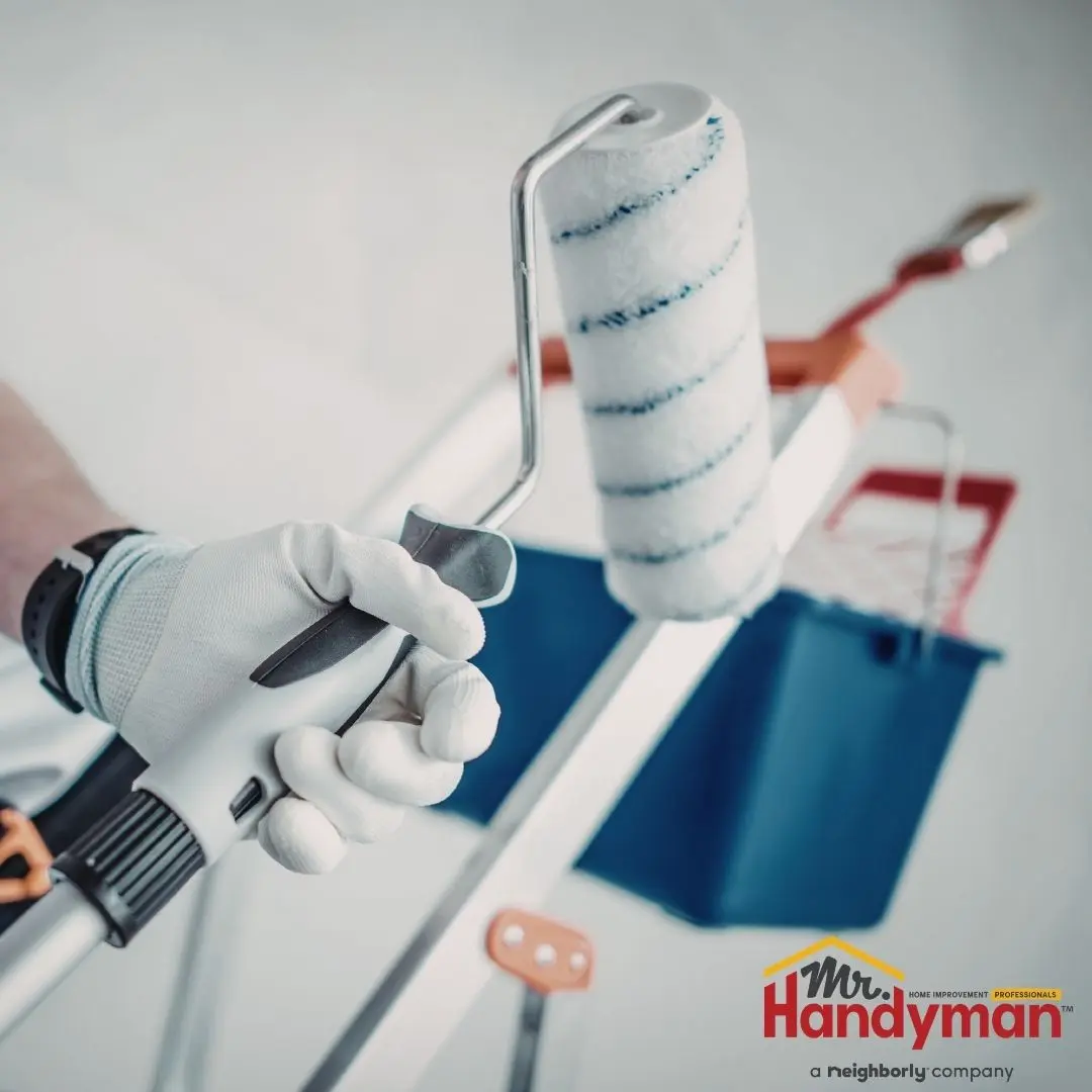 A close-up shot of a person holding a paint roller.