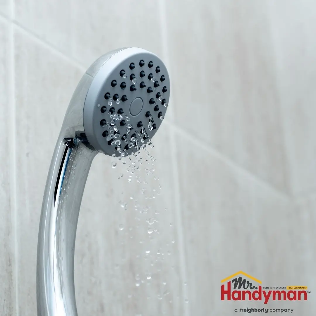 handyman inspecting a pressure regulator valve on a home water supply