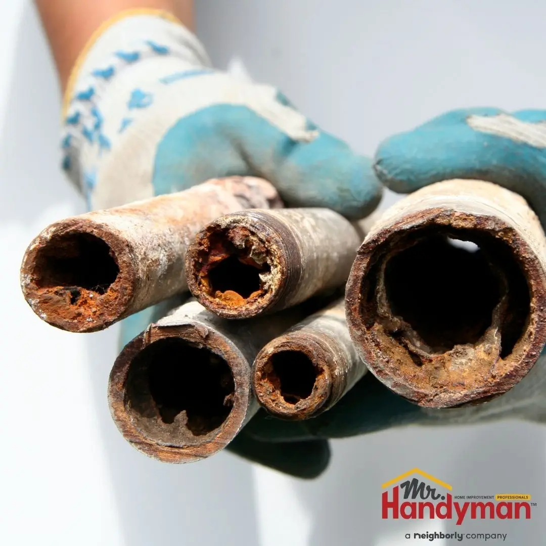 handyman inspecting a pressure regulator valve on a home water supply line in South Bend Indiana