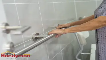 Mr. Handyman technician installing grab bars and a handrail in a bathroom for aging-in-place safety in a Charles Town, West Virginia home.