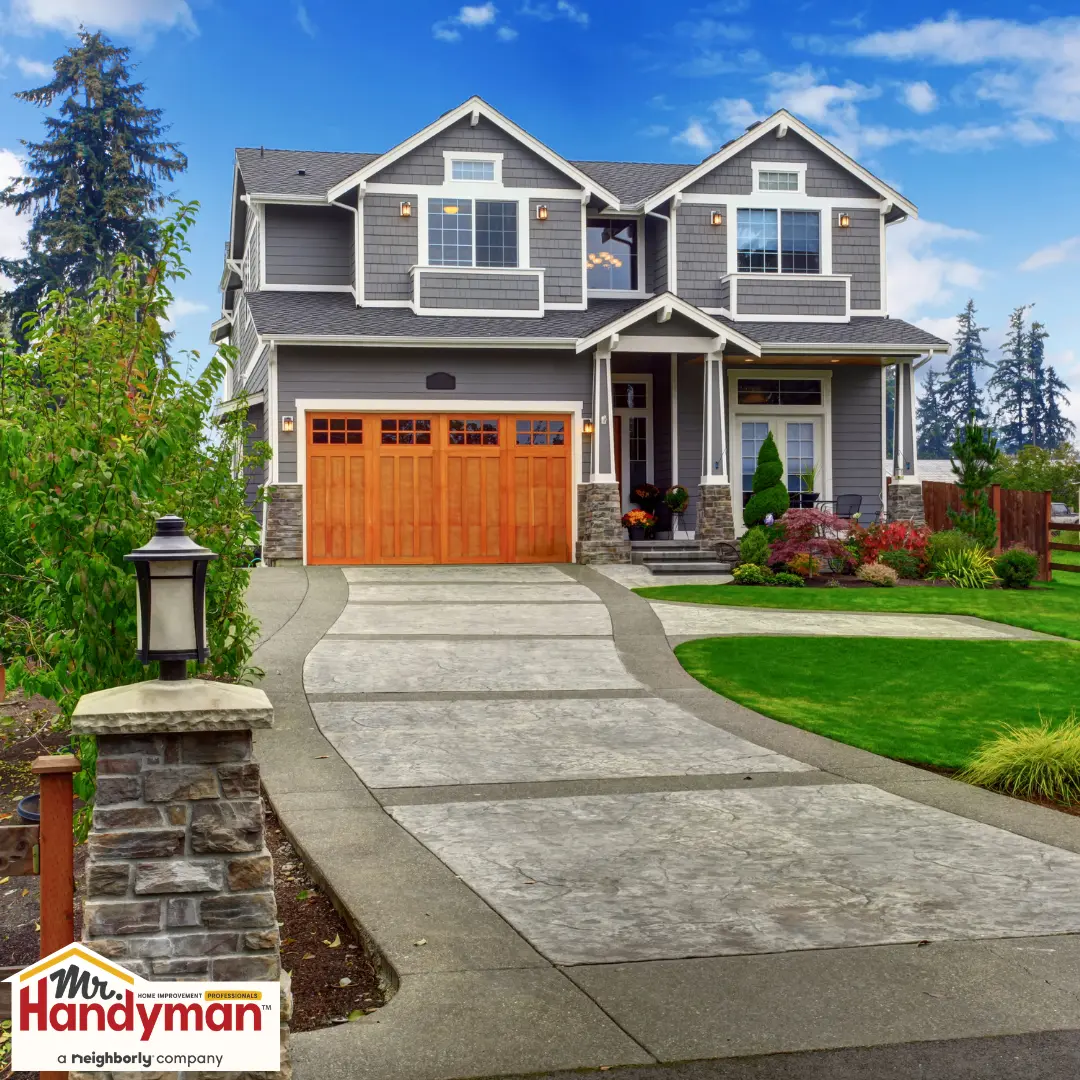 Spacious house with a grey facade and wooden garage doors.