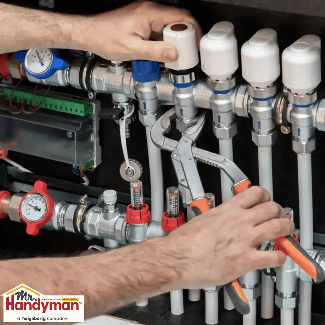 Hands using pliers to adjust valves and pipes.
