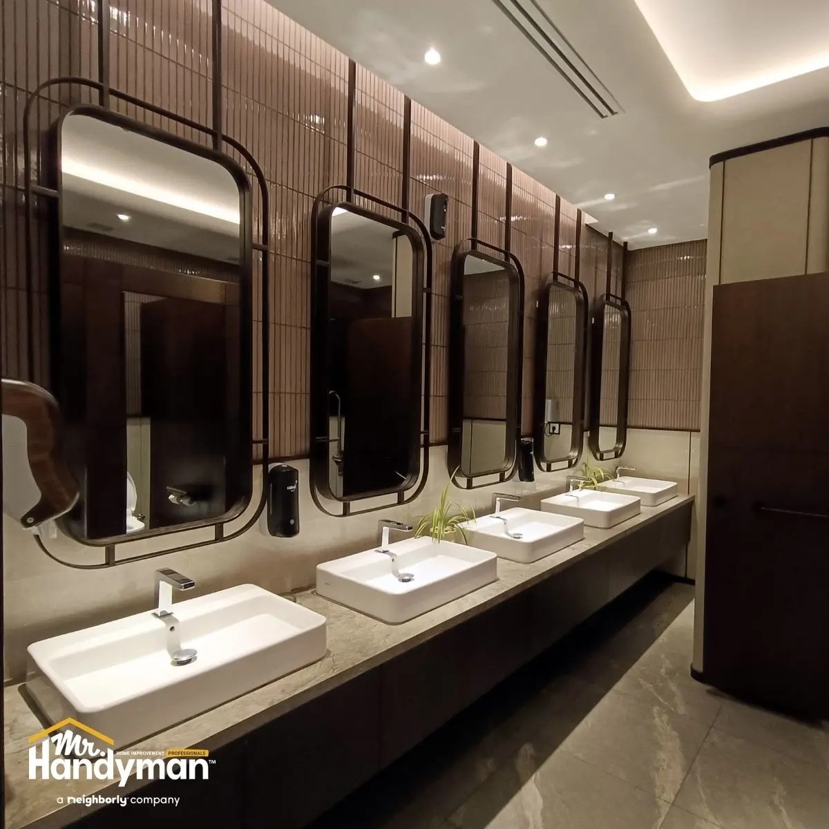 A modern restroom with five rectangular mirrors above white sinks.