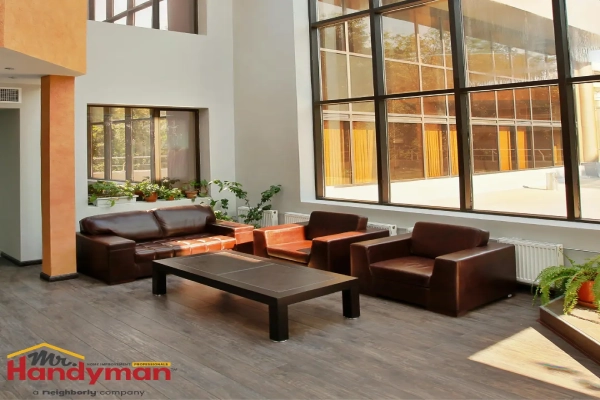 A modern reception area with large windows, brown leather seating, and a minimalist coffee table.