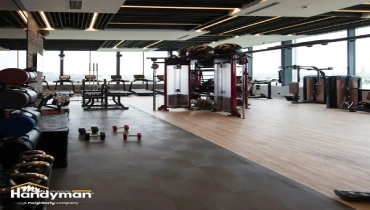 Modern gym interior with large windows showing city view.