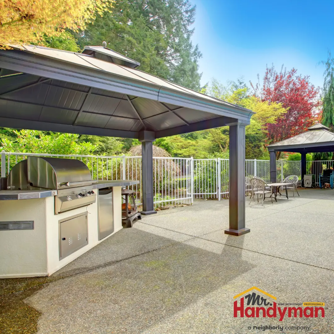 A built-in outdoor grill island sits on a concrete patio.