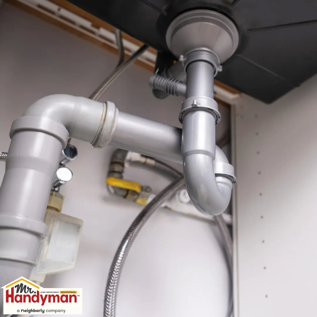 plumber inspecting basement sump pump after spring storm flooding in South Bend Indiana