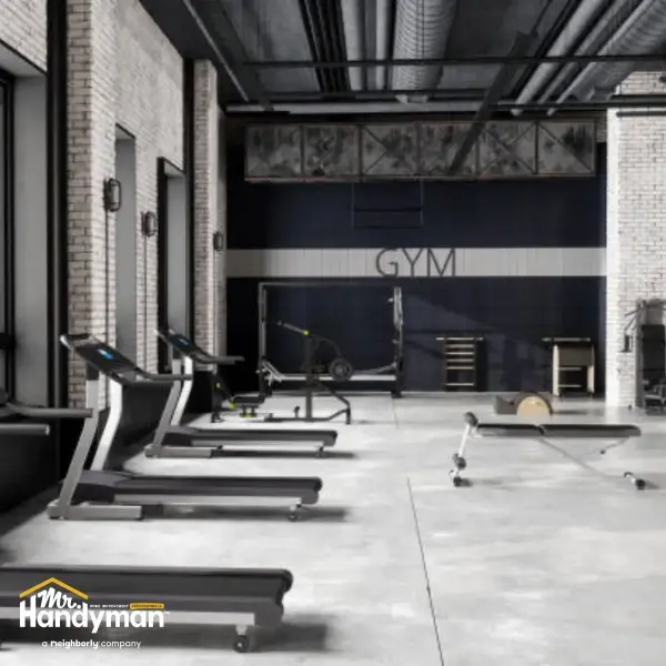Mr. Handyman technician servicing commercial door hardware and locks at a South Bend Northern Indiana fitness facility