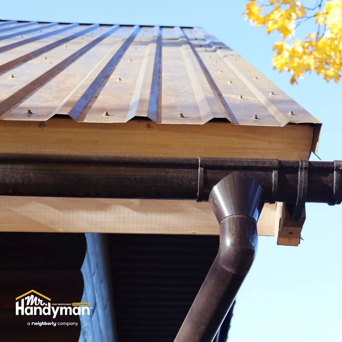 Close-up of a rusty metal roof and black gutter system.