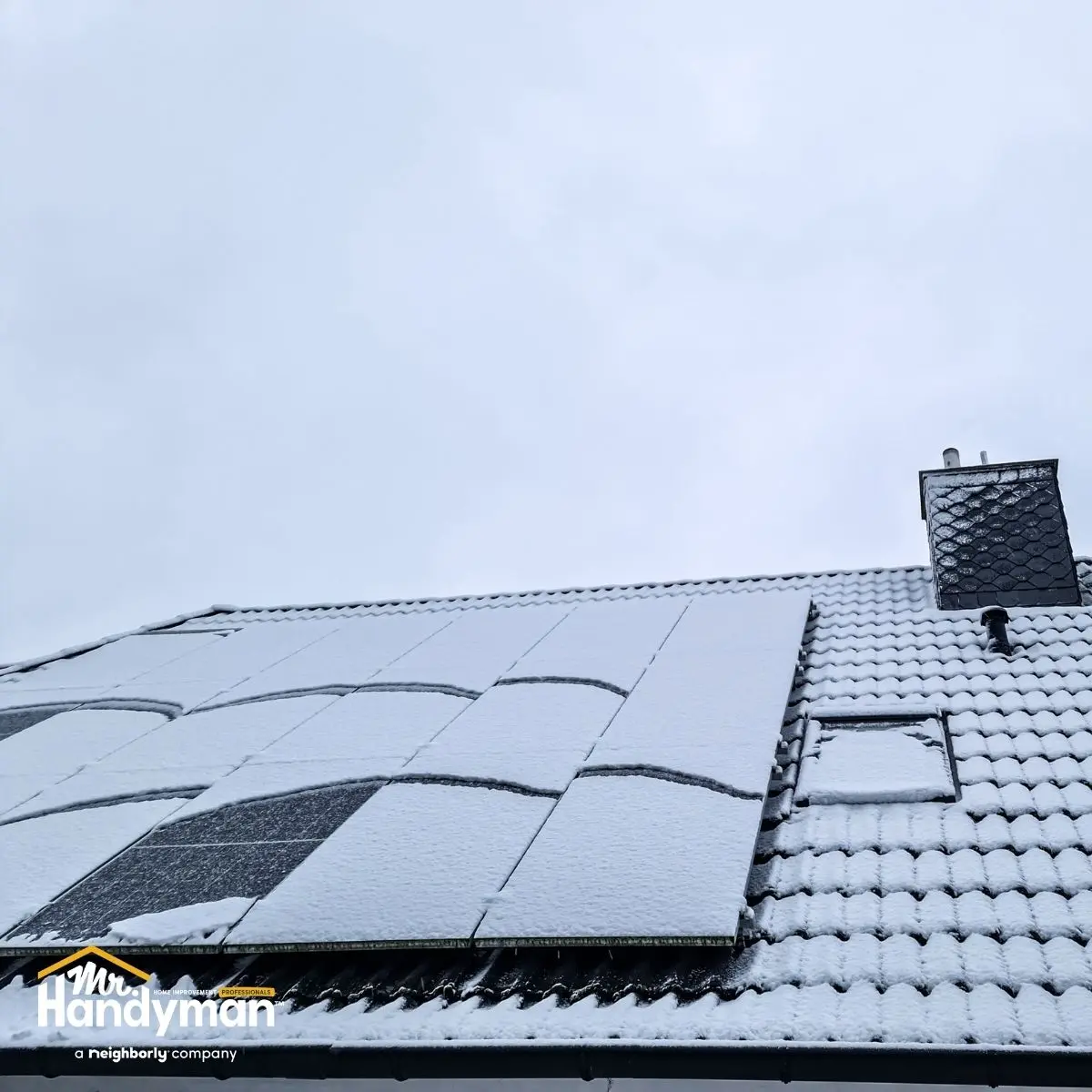 Snow-covered solar panels and roof tiles.