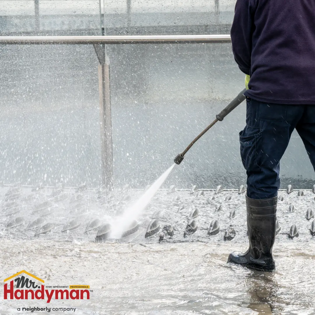 Mr. Handyman technician cleaning exterior surfaces and servicing entry doors at a commercial property in Greensburg, Pennsylvania