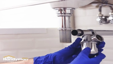 Mr. Handyman technician repairing locker room plumbing fixtures at Wichita area fitness facility