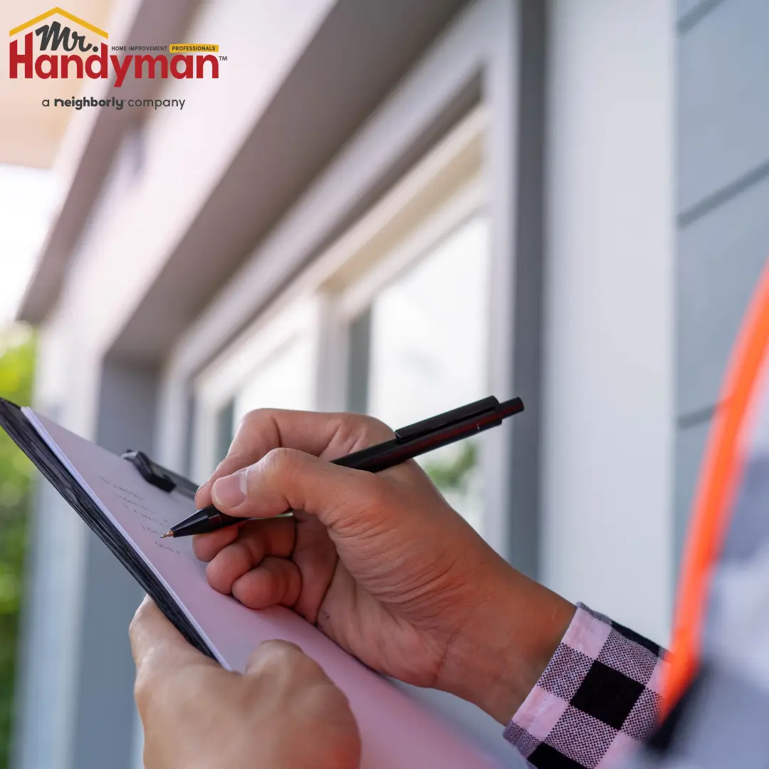 A person holding a clipboard and writing with a pen.