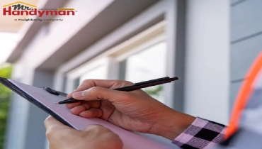 A person holding a clipboard and writing with a pen.