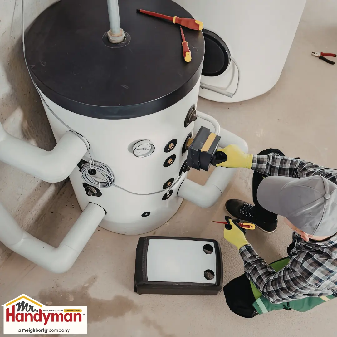 Technician repairing a large white water heater with tools.