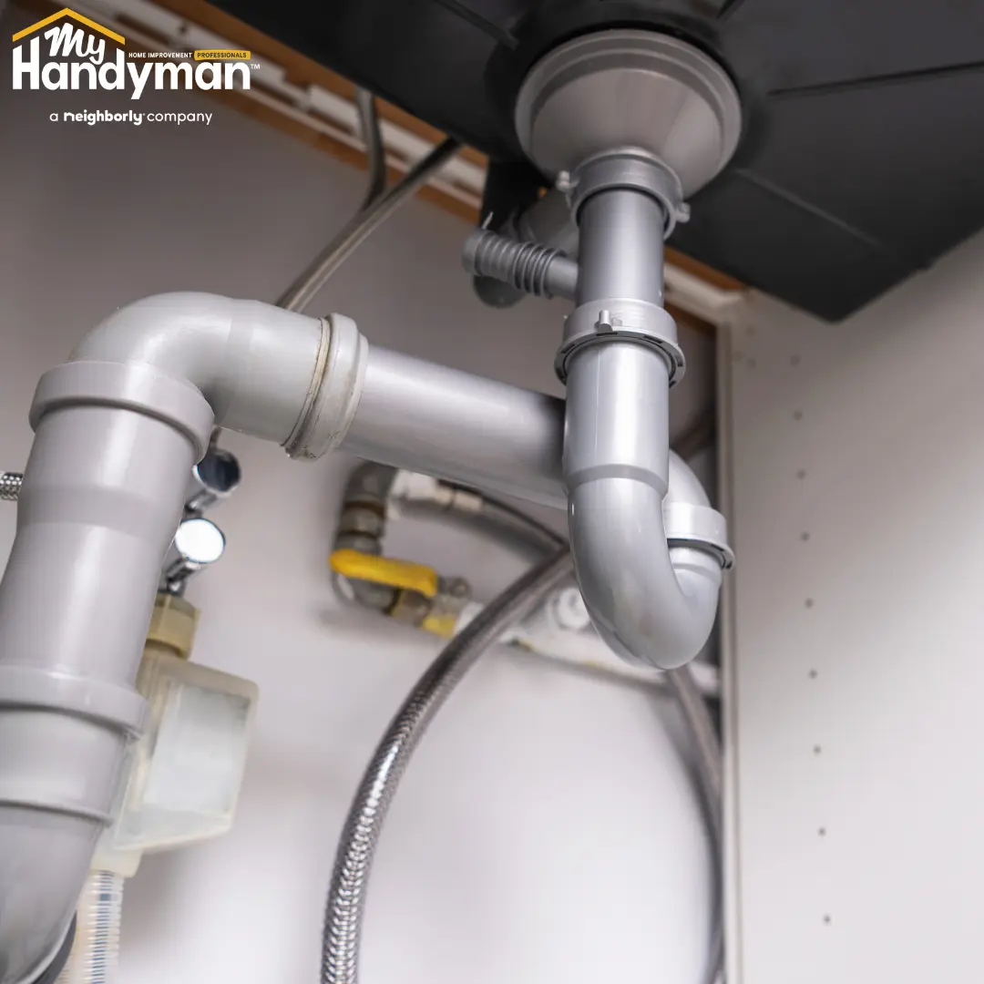 Handyman inspecting a water shutoff valve before summer travel at a home in Rock Hill South Carolina