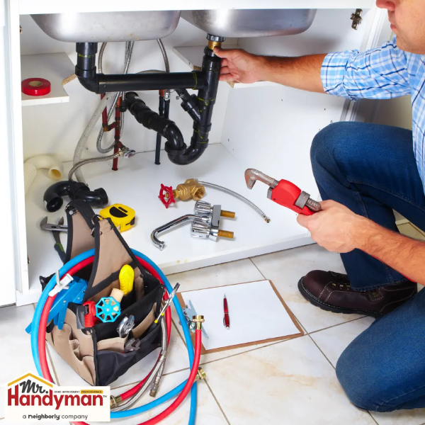 A man kneeling down in a bathroom, working on a plumbing project.
