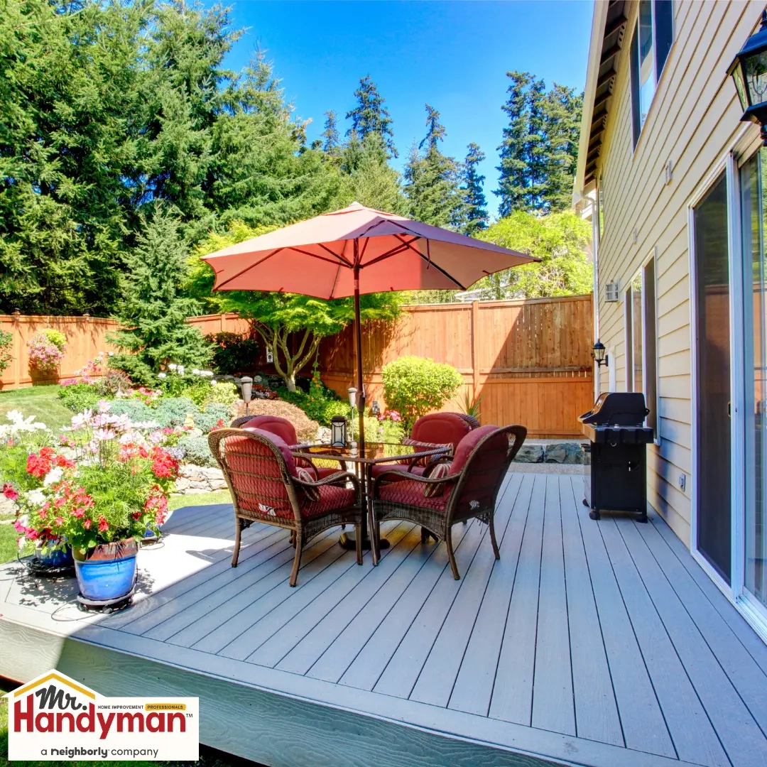 A backyard deck with beautiful furniture and a garden view.