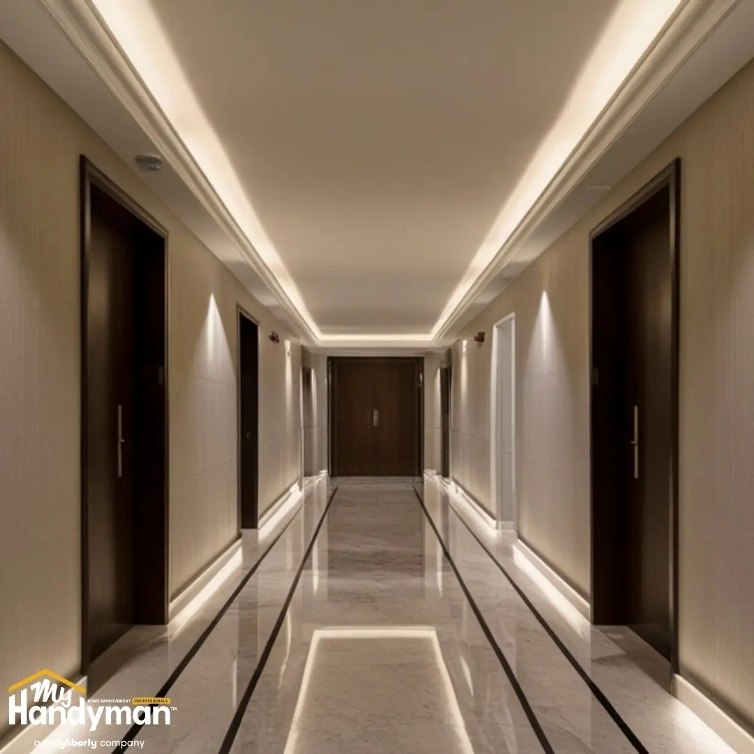 A modern hallway featuring ambient lighting along the ceiling and walls.