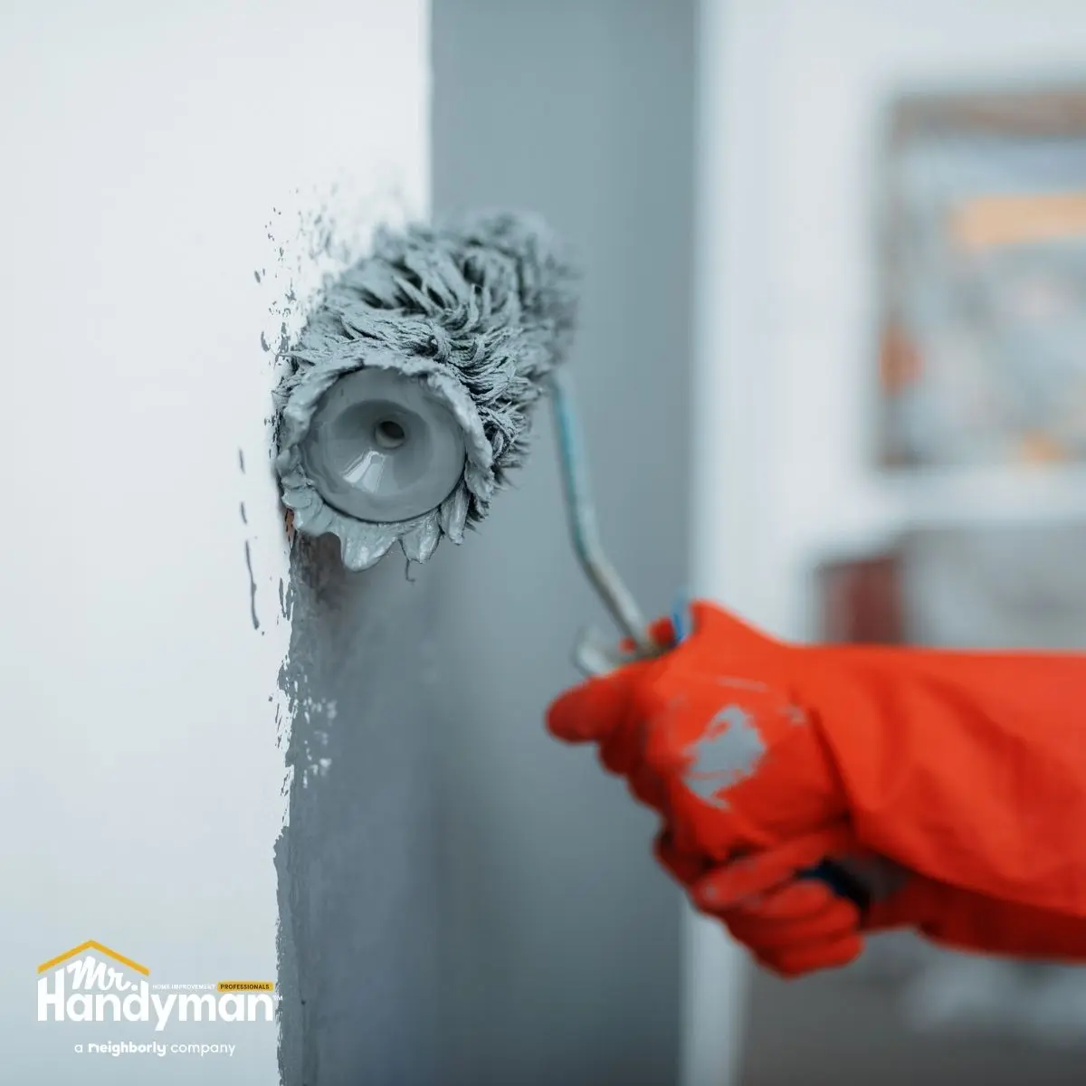 A person is painting a wall with a roller brush.