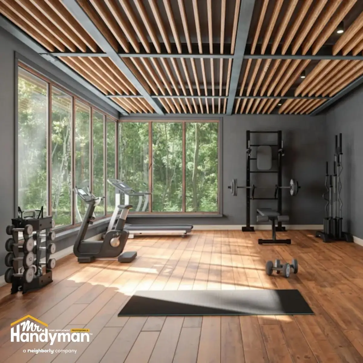 Modern home gym with large windows overlooking greenery.