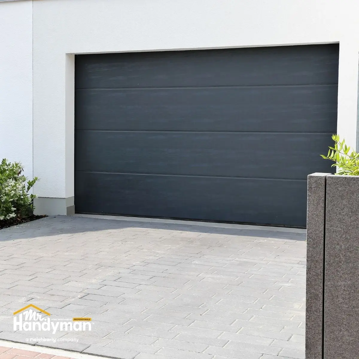Modern gray garage door on a white wall.