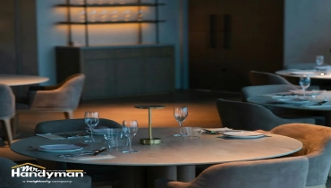Dining tables set with glassware and napkins in a softly lit.