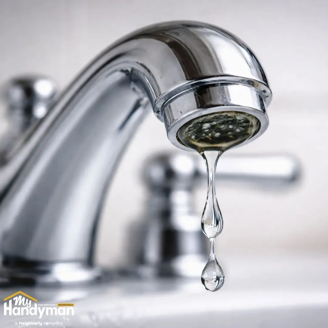 Close-up of a faucet with a drip of water.