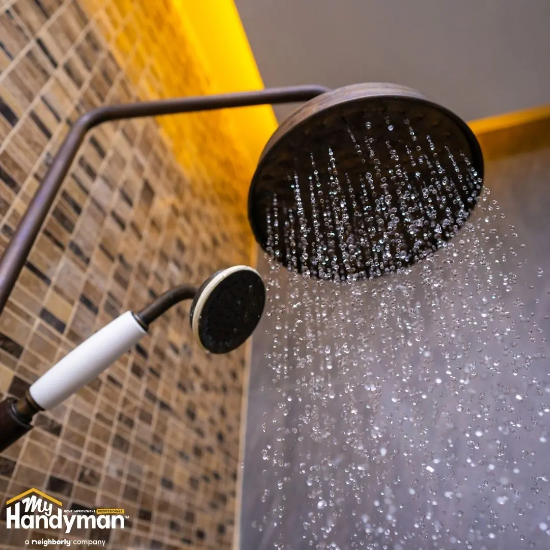 Close-up of a modern rainfall showerhead pouring water.