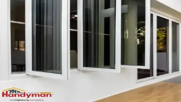 Handyman installing a replacement window in a West Nashville, TN home.
