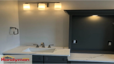 Bathroom vanity with modern triple light fixture installed by Mr. Handyman of Northern Montgomery County.