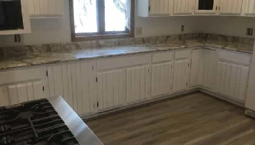 A residential kitchen with new, white cabinets installed by Mr. Handyman during a kitchen renovation project.