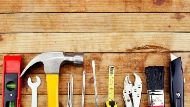 A variety of tools kept on a wooden table.