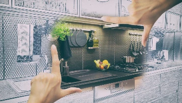 A hand framing a kitchen.