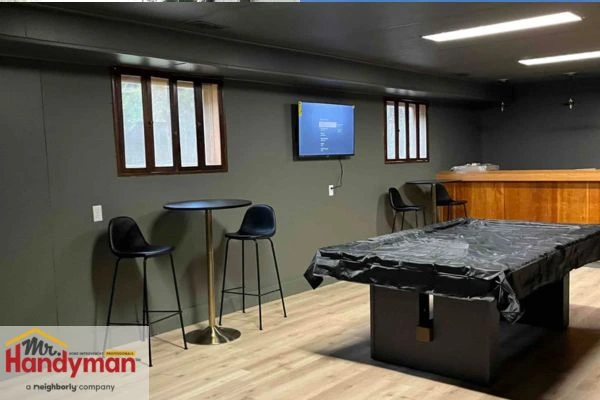 Home theater setup in finished basement with seating and screen installed by Mr. Handyman