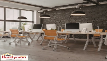 Modern open plan office workspace with chairs near large windows.