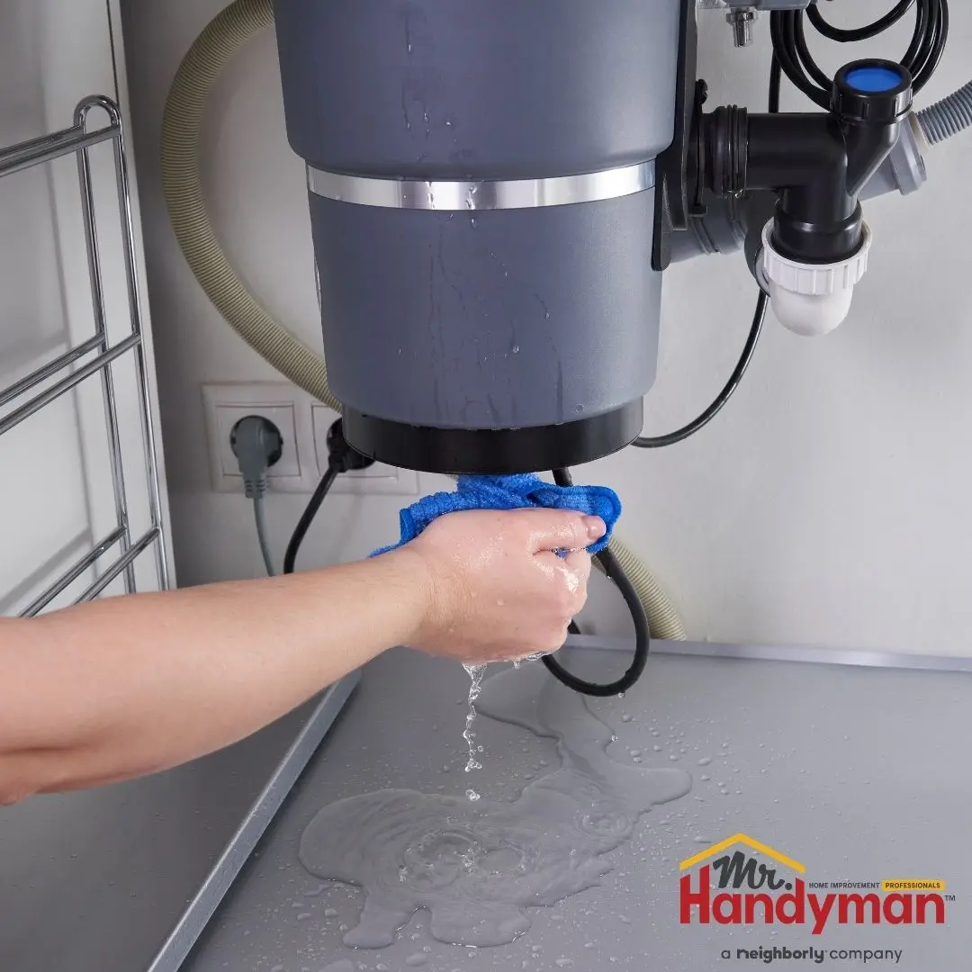 Handyman inspecting a garbage disposal under a kitchen sink in Murfreesboro Tennessee