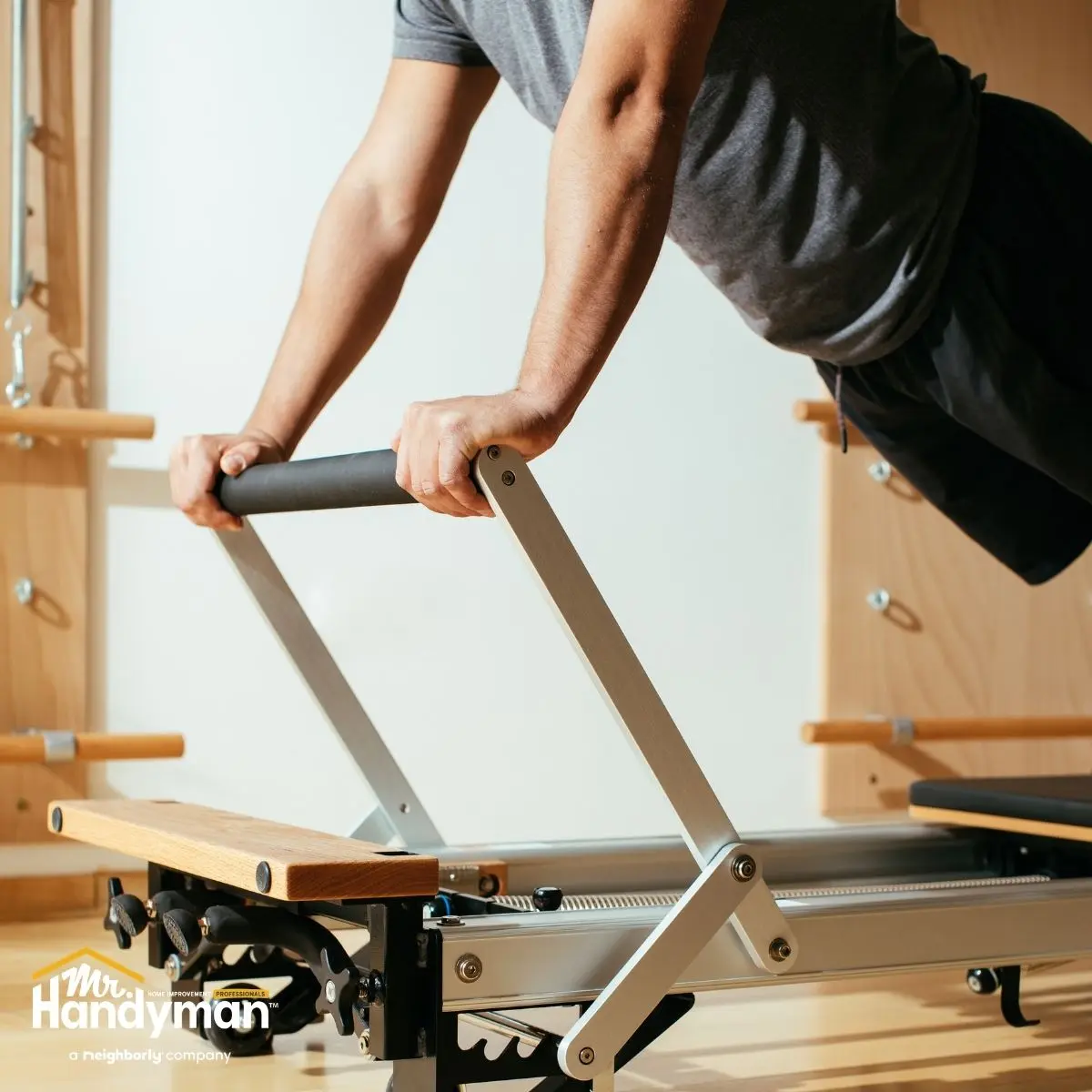 Person using pilates reformer machine.