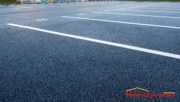 Mr. Handyman technician assessing commercial parking lot crack and biological growth conditions at a Charleston, South Carolina business property
