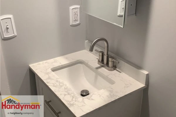 Double-sink vanity with wood cabinetry and LED mirror installed by Mr. Handyman