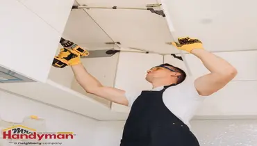 Handyman performing routine home maintenance inspection at a residential property