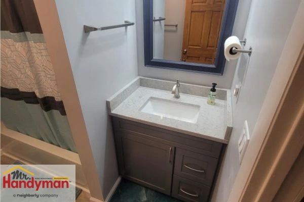 Double-sink vanity with wood cabinetry and LED mirror installed by Mr. Handyman